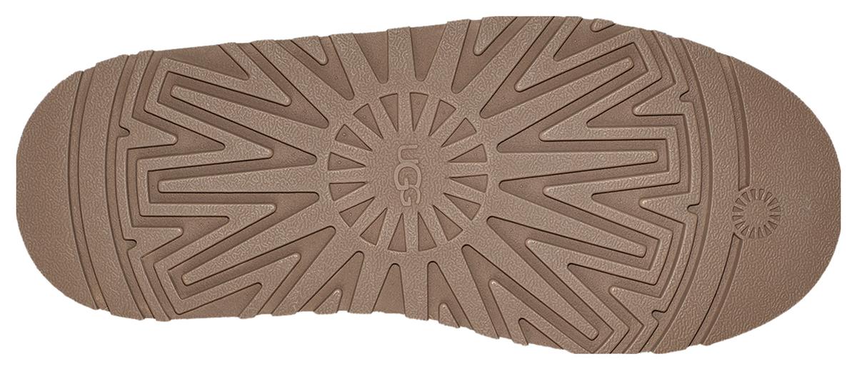 UGG Tazz Chestnut tabanı alttan: ortada UGG logosu ve ondan kenarlara açılan derin ışınsal desen